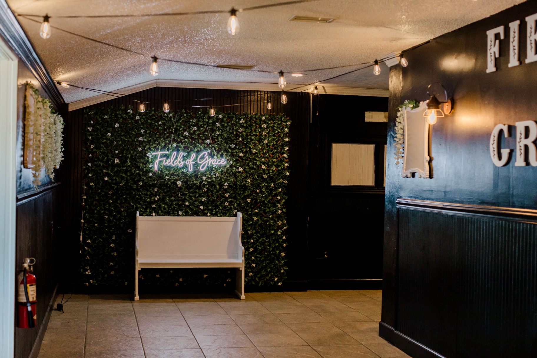 The Entry — Greenery wall & neon welcome at Fields of Grace Farmhouse in Lake Butler, FL