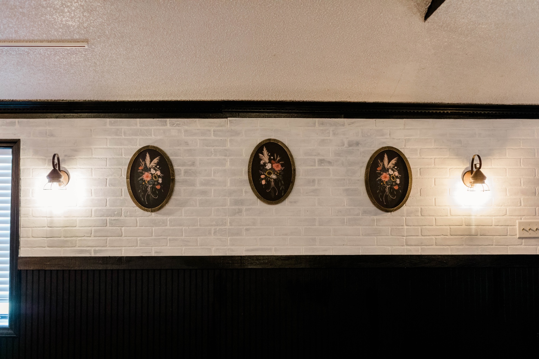 Botanical Details — Framed florals on white brick at Fields of Grace Farmhouse in Lake Butler, FL